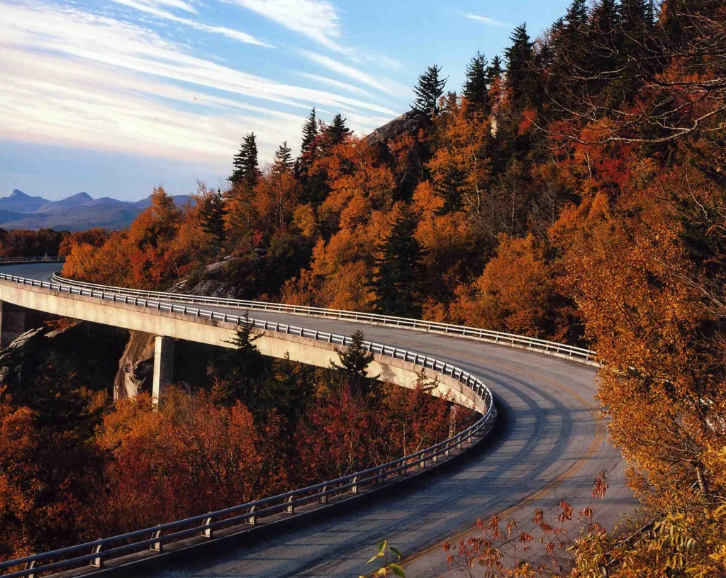 Linn Cove Viaduct curving through orange autumn forest below Grandfather Mountain